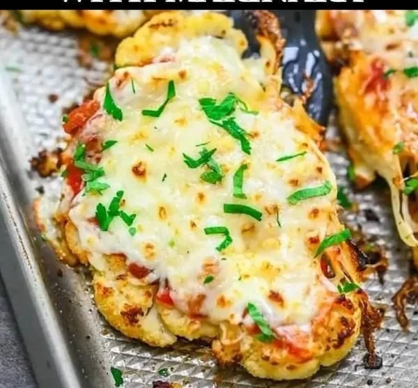 Cauliflower steaks drizzled with marinara sauce on a plate