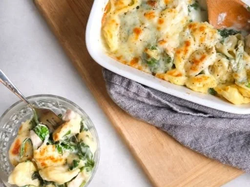 Baked Chicken Tortellini dish topped with cheese and herbs