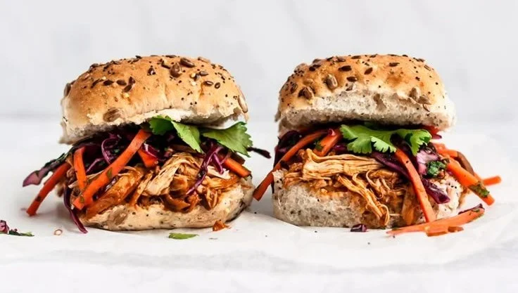 Delicious easy pulled chicken sandwiches served with toppings on a plate