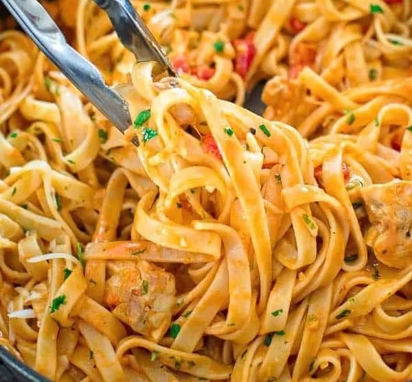 Pasta with chicken and roasted pepper sauce served in a bowl